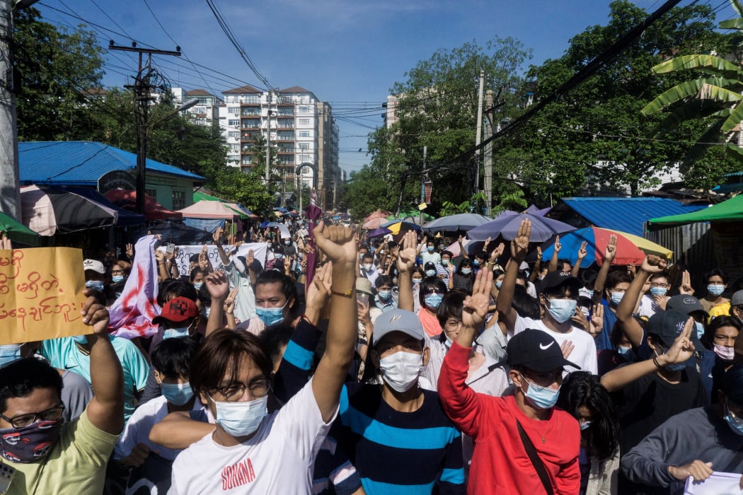 Protesters make the three-finger salute during a demonstration against the military coup in Yangon on 14 May, 2021.