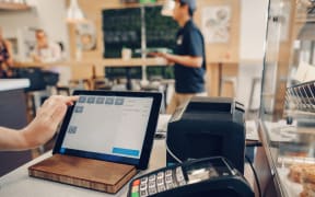 Closeup shot of caucasian cashier hands. Seller using touch pad for accepting client customer payment. Small business of coffee shop cafeteria.
