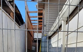 Temporary fencing and ply sheets confront Vanila Ekenasio on daily trips back to her Kilbirnie home to feed the cat, Beauty, who has refused to leave.