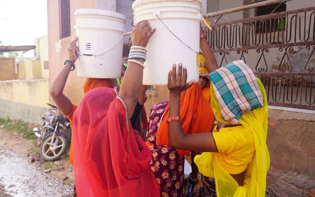 Indian Villagers collects drinking water from a road side water tap during a hot summer day on the outskirts Village of Ajmer, Rajasthan, India on 11 June 2021. (Photo by Himanshu Sharma/NurPhoto) (Photo by Himanshu Sharma / NurPhoto / NurPhoto via AFP)