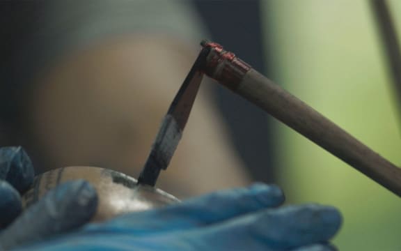 A close-up of the knee being tattooed