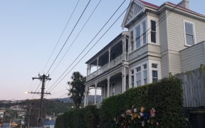 Flower bouquets have been left outside a house on Dundas Street, Dunedin, where a university student died after being fatally hurt at an overcrowded part.
