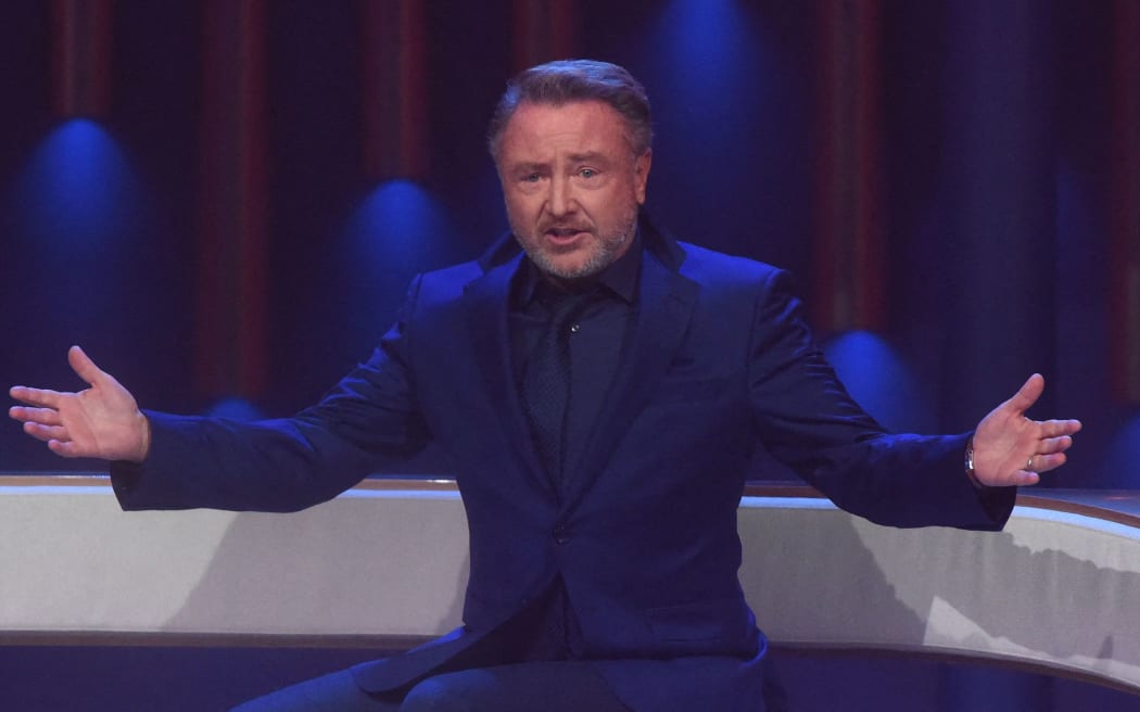 13 November 2021, Bavaria, Geiselgasteig: Michael Flatley, director Lord of the Dance, sits on stage during "The Giovanni Zarrella Show", The second edition of the SDF music show "The Giovanni Zarrella Show" was broadcast live from Munich's Bavaria Studios. Photo: Felix Hörhager/dpa (Photo by Felix Hörhager / DPA / dpa Picture-Alliance via AFP)