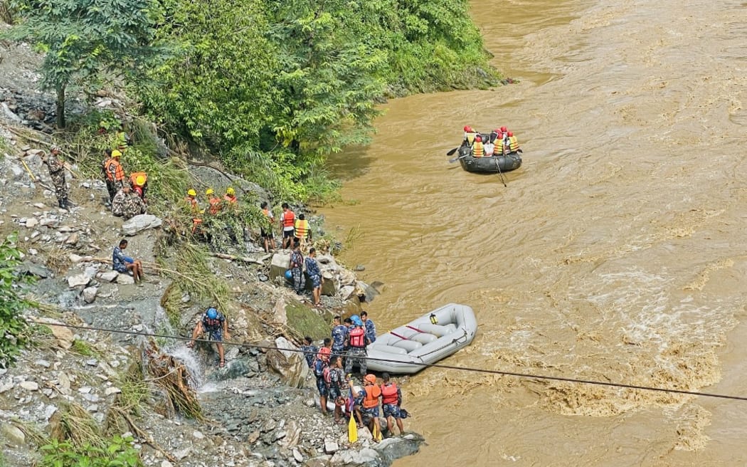 Rescuers search for survivors in river Trishuli in Simaltar on July 12, 2024, at the site of a landslide. At least 63 people were missing in Nepal on July 12 after a landslide triggered by heavy monsoon rains swept two buses off a highway and into a river, authorities said. (Photo by RAJESH GHIMIRE / AFP)