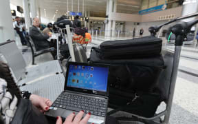 Woman at Beirut international airport checking laptop. March 2017.