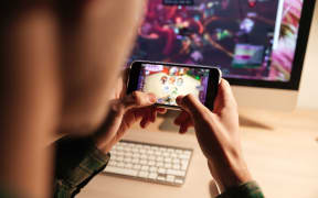Closeup of man playing videogame on smartphone.