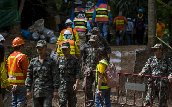 Thai soldiers and volunteers are seen at the entrance of Tham Luang cave.