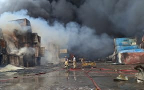 Firefighters and rescuers work at the scene of an explosion that took place a day earlier at the Shahid Rajaee port dock, southwest of Bandar Abbas in the Iranian province of Hormozgan, on April 27, 2025. Fire blazed on April 27, around 24 hours after a massive explosion tore through Iran's largest commercial port, killing at least 28 people and leaving more than 1,000 others injured, according to the Red Crescent. (Photo by Meysam Mirsadeh / TASNIM NEWS / AFP)