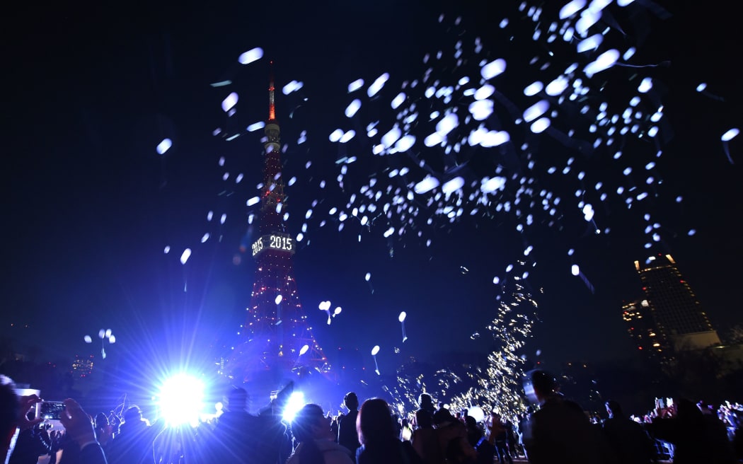 People release balloons beside the Tokyo Tower to celebrate the New Year.