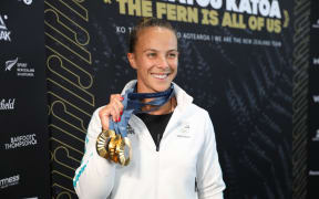 Dame Lisa Carrington shows off her three gold medals from the Paris Olympic Games 2024.