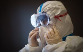 A member of the medical team of the Second Military Medical University puts on protective clothing at Hankou Hospital in Wuhan on 27 January, 2020.