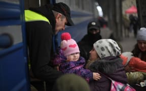 People fleeing Ukraine board a train in Lviv, in the west of the country, en route to Poland, 3 March 2022.