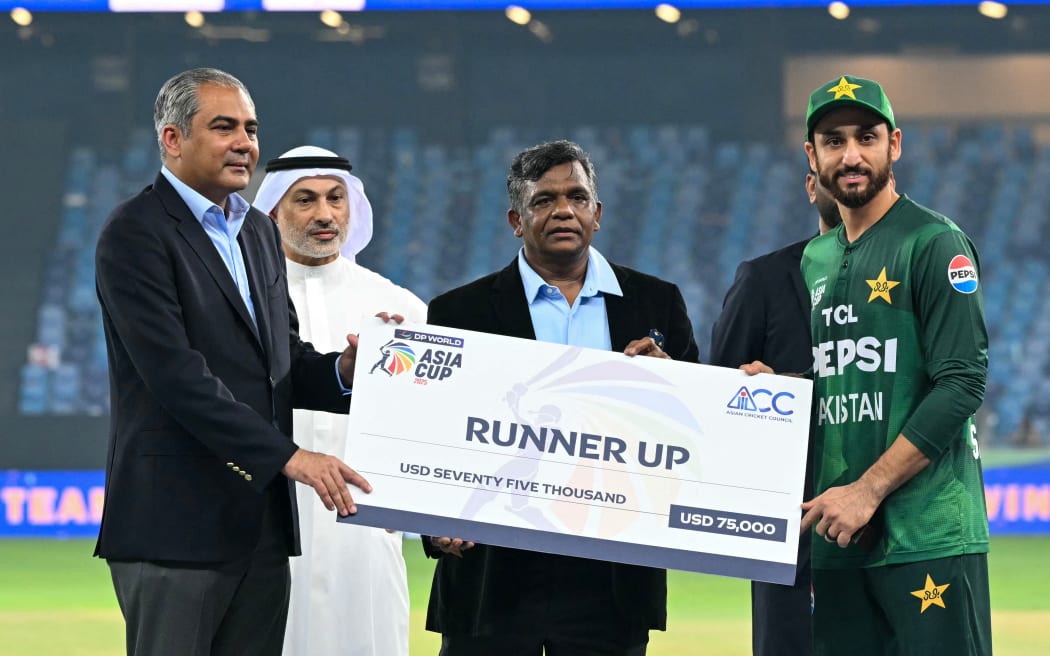Pakistan's captain Salman Agha (R) receives the runner up cheque from Asian Cricket Council (ACC) and Pakistan Cricket Board (PCB) chairman Mohsin Naqvi (L) during the presentation ceremony at the end of the Asia Cup T20 cricket final in Dubai.
(Photo by Sajjad HUSSAIN / AFP)