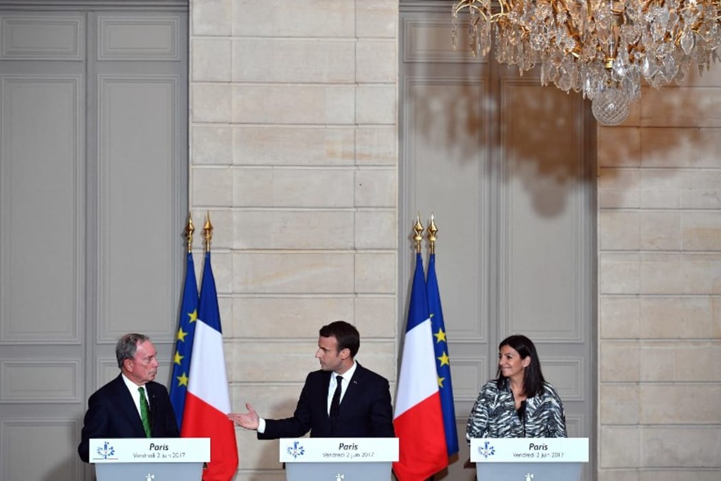 French President Emmanuel Macron (C), Paris Mayor Anne Hidalgo (R) and former mayor of New York City Michael Bloomberg speak during a press conference after their meeting at the Elysee Palace in Paris