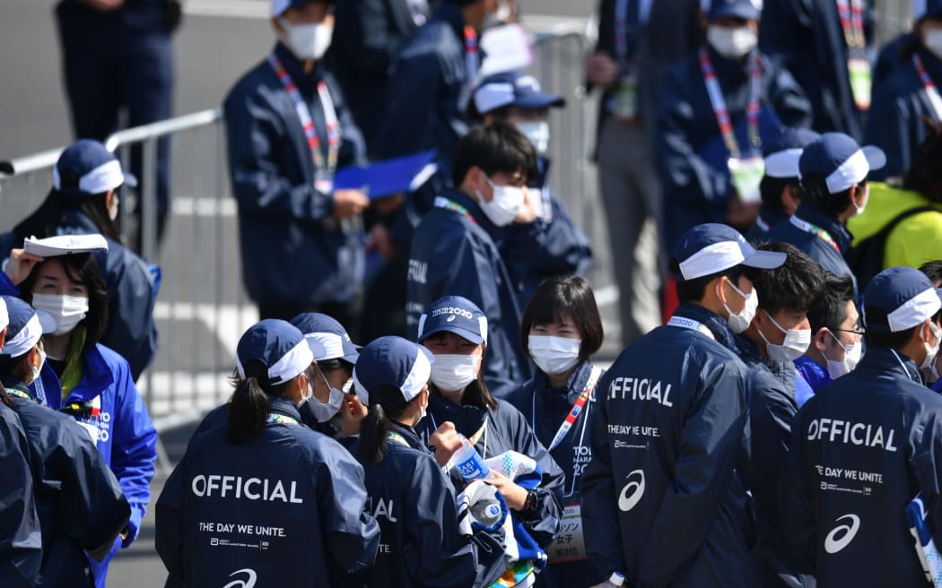 Volunteers in Tokyo wear protective face masks as a precaution against the coronavirus,