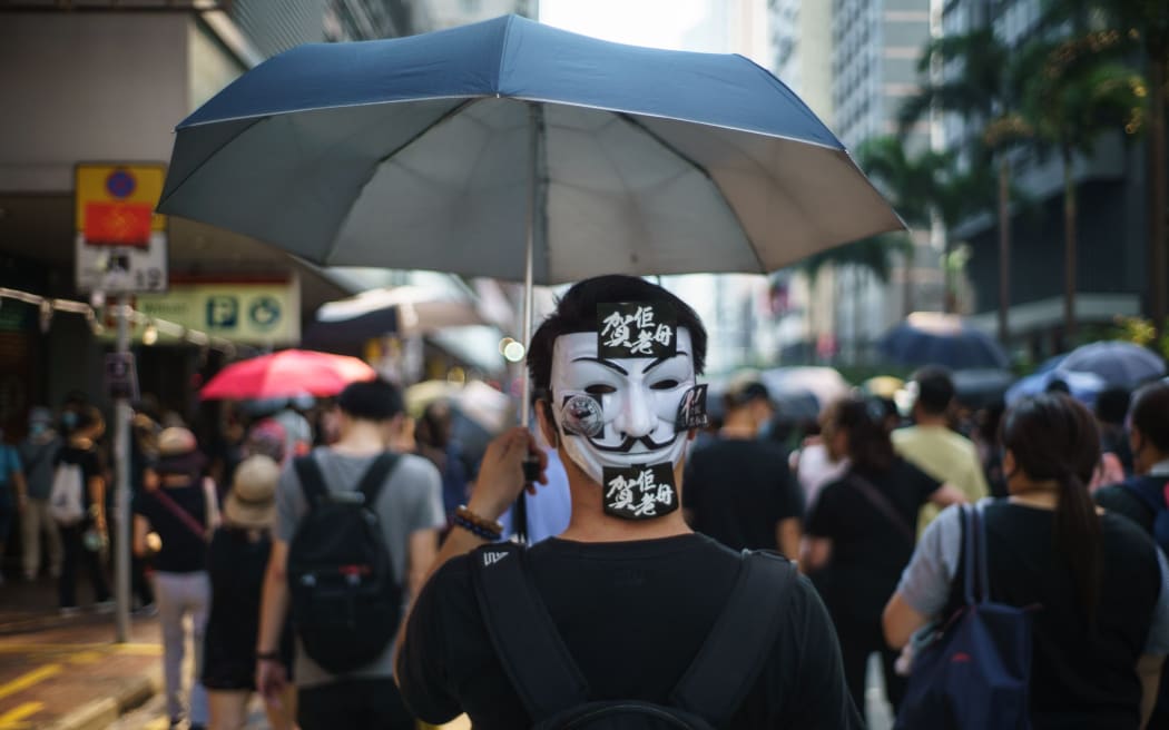 In this picture taken on October 1, 2019, a protester wears a Guy Fawkes mask on the back of his head, popularised by the V For Vendetta comic book film, in Hong Kong.