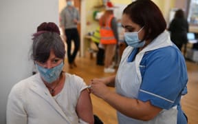 A woman receives a dose of the Moderna Covid-19 vaccine in Belper, Derbyshire, as the UK steps up its booster drive to fight Omicron.