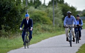 Britain's Prime Minister Boris Johnson (L) and Conservative MP for Broxtowe Darren Henry ride bicycles at the Canal Side Heritage Centre in Beeston.