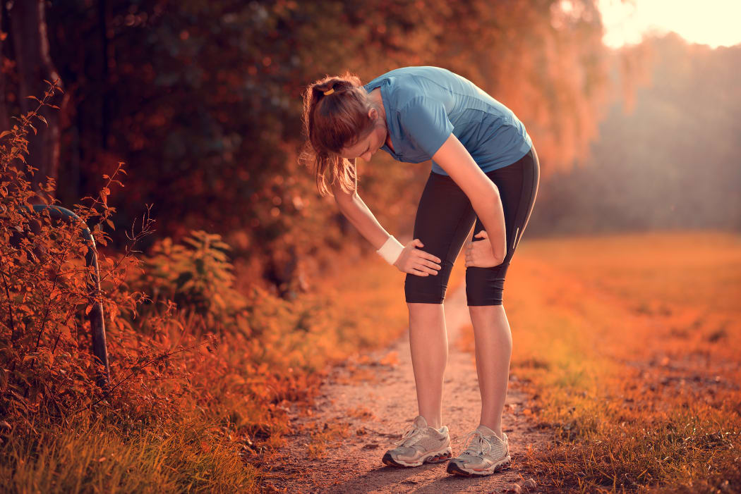 Young athletic woman taking a break from training standing resting, fatigue.