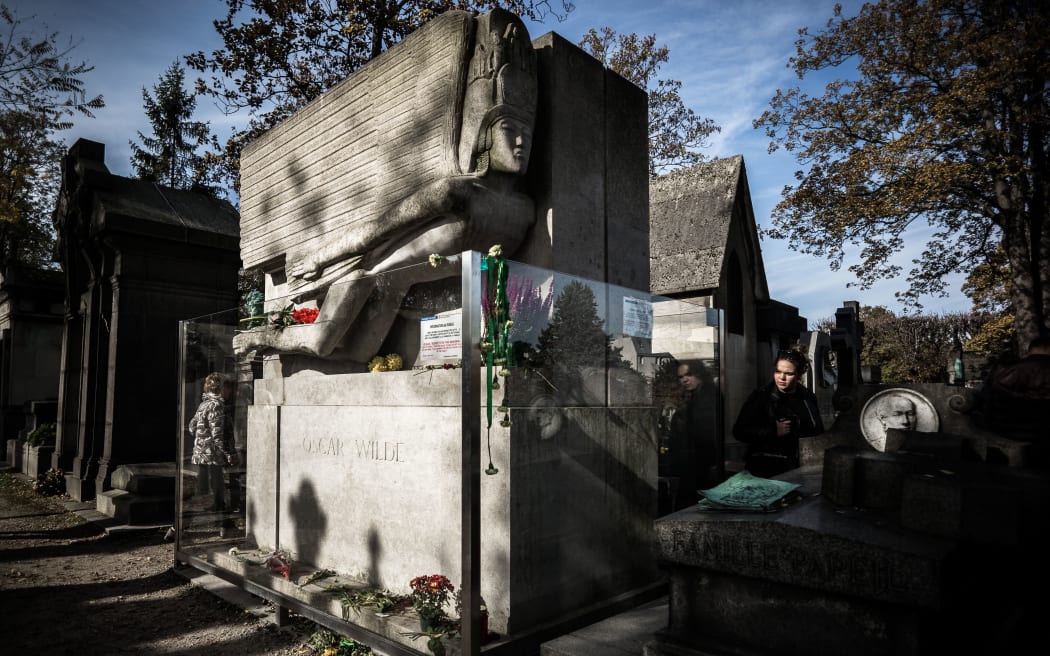 A visitor walks past the grave of Oscar Wilde at the Pere Lachaise cemetery during All Saints' Day in Paris on November 1, 2016. (Photo by PHILIPPE LOPEZ / AFP)