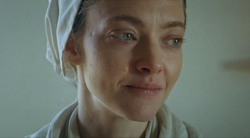 Amanda Seyfriend, wearing a headscarf, looks emotional and barefaced.