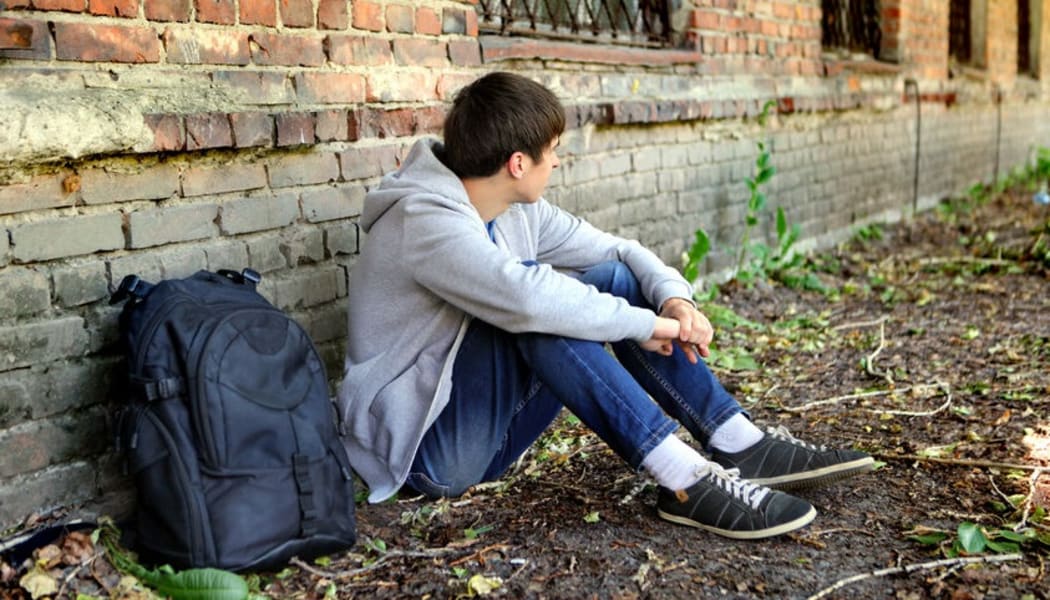 45247047 - sad teenager near the brick wall of the old house