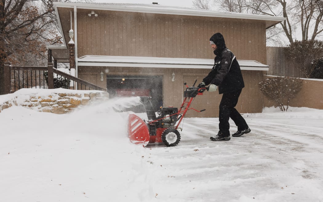 SHAWNEE, KANSAS - JANUARY 5: Darin Campbell uses a snow blower to remove snow from his driveway on January 5, 2025 in Shawnee, Kansas. A large swath of the U.S., across the Midwest to the East Coast is experiencing a major Winter storm, with more than two feet of snow in some areas. A state of emergency has been declared in Kentucky and Virginia.   Chase Castor/Getty Images/AFP (Photo by Chase Castor / GETTY IMAGES NORTH AMERICA / Getty Images via AFP)