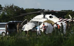 Police and military personnel around a helicopter at a Chiang Rai military air base on 9 July, when four more boys were rescued from a flooded cave.