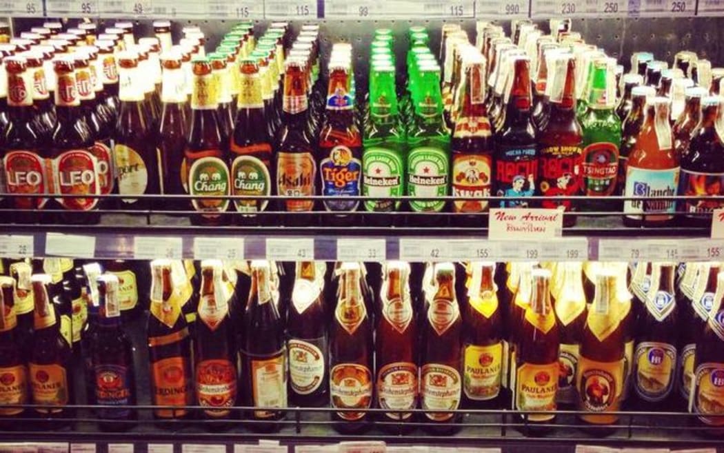 A supermarket shelf stocked with bottles of imported beer.