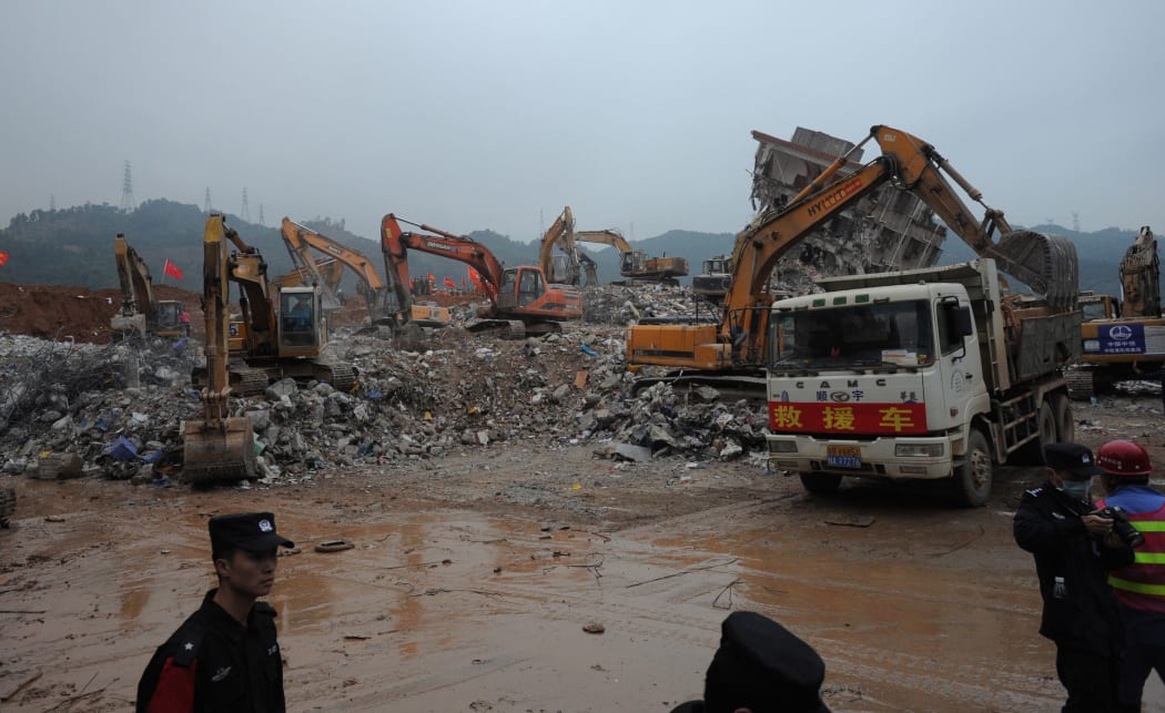Excavators work at the site of the landslide that hit the industrial park in Shenzhen on December 22, 2015. CHINA OUT AFP PHOTO / STR