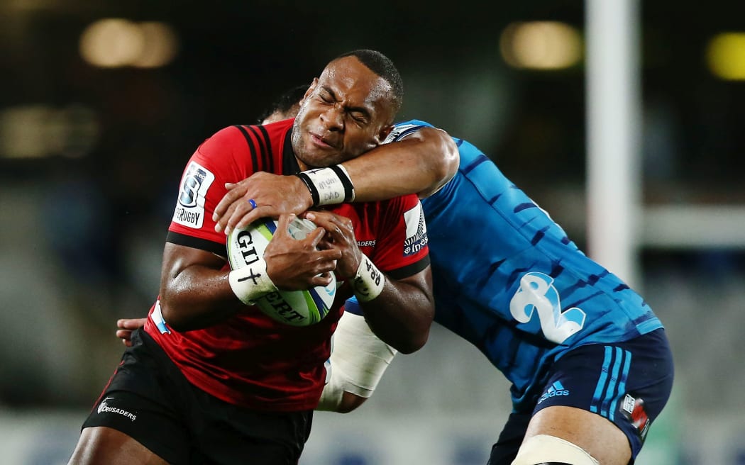 Manasa Mataele of the Crusaders is tackled by Jerome Kaino of the Blues.