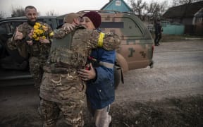 Ukrainian citizens welcome Ukrainian soldiers with flowers in the village of Kyselivka as the Ukrainian military enters the southern city of Kherson after the Russian retreat from the region on November 12, 2022.