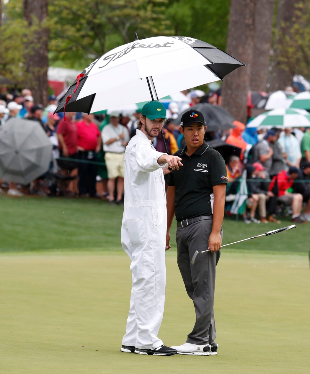 Jeunghun Wang talks to his caddie during the 2017 Masters Tournament.