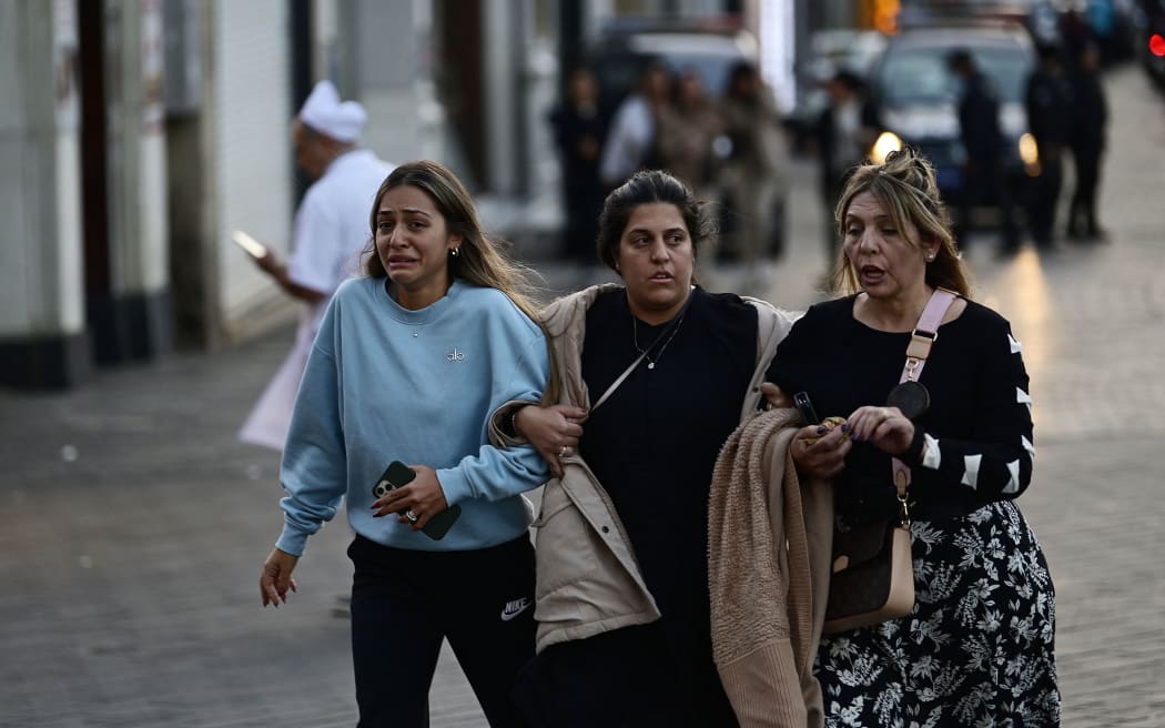 People leave Istiklal Avenue after a huge explosion on the busy Istanbul shopping street, on 13  November 2022.