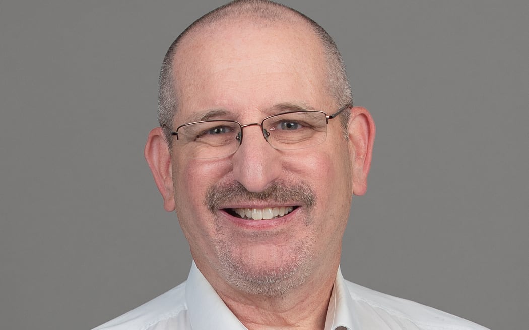 Todd Zaner smiling with grey background