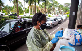 A health worker prepares a dose of the AstraZeneca vaccine for a resident at a drive-through vaccination centre in Suva.