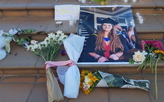 An image of Grace Millane surrounded by flowers at a vigil in Wellington. 12 December 2018