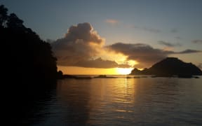 Sun sets behind Tonga Island in the Abel Tasman National Park.