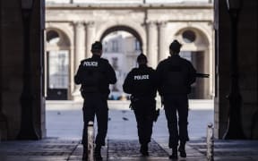 Police secure the area in front of the Louvre.