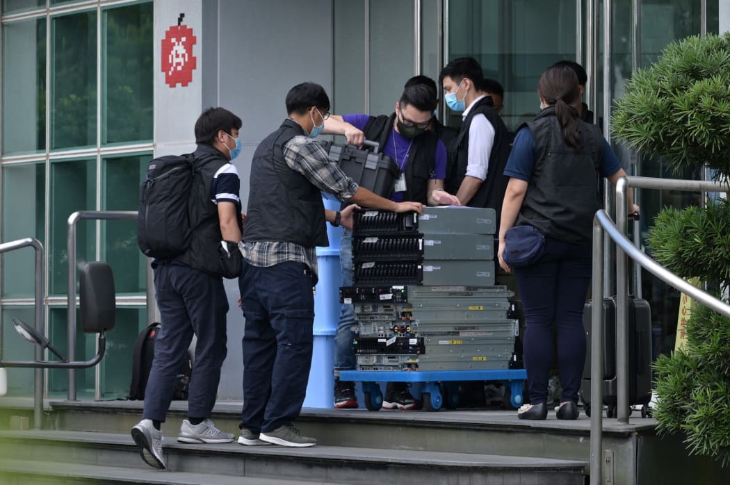 Police handle evidence taken from the Apple Daily newspaper offices before being put into a waiting vehicle in Hong Kong on 17 June, 2021.