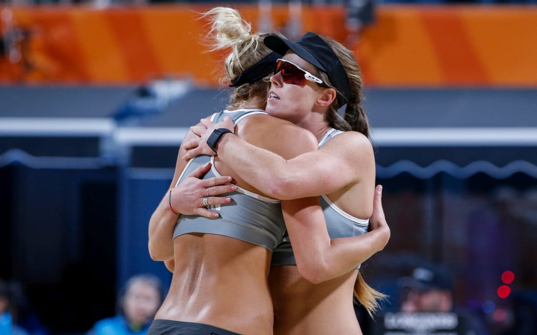 New Zealanders Alice Zeimann and Shaunna Polley embrace during their beach volleyball  semifinal at the Birmingham Commonwealth Games.