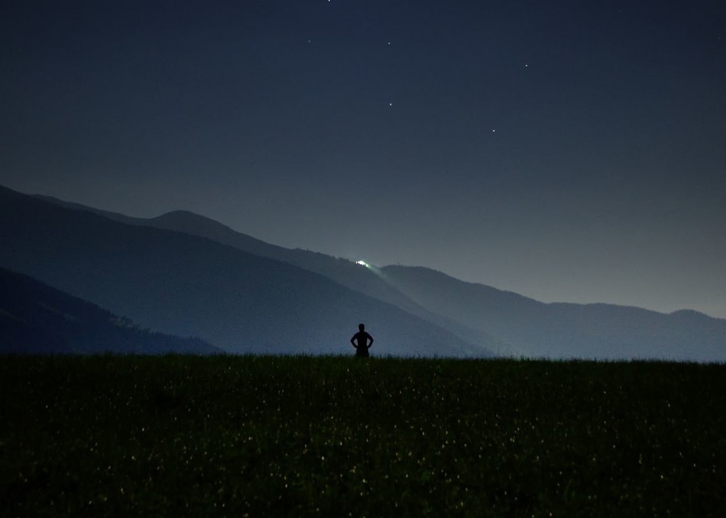 person alone in mountains at night
