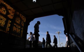 This photo taken on June 5, 2019 shows Uighur men walking past the exit of an underpass after attending Eid al-Fitr prayers, marking the end of Ramadan, in Kashgar in China's northwest Xinjiang region.