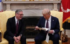 US President Donald Trump reads a letter from Britain's King Charles III handed to him by British Prime Minister Keir Starmer (L) during a meeting in the Oval Office of the White House in Washington, DC, on February 27, 2025. Starmer is meeting Trump to plead for a US backstop to any Ukraine ceasefire, insisting it would be the only way to stop Russia's Vladimir Putin from invading again. Starmer arrived in Washington late Wednesday to build on a visit by French President Emmanuel Macron, amid growing concerns in Europe that the US leader is about to sell Kyiv short in negotiations with Putin. (Photo by Carl Court / POOL / AFP)
