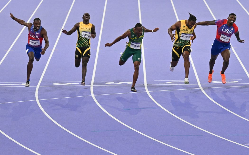 Winner Noah Lyles (L) of the United States crosses the finish line ahead of Jamaica's Kishane Thompson (2R), US' Fred Kerley (R) in the Paris Olympics men 100m final.