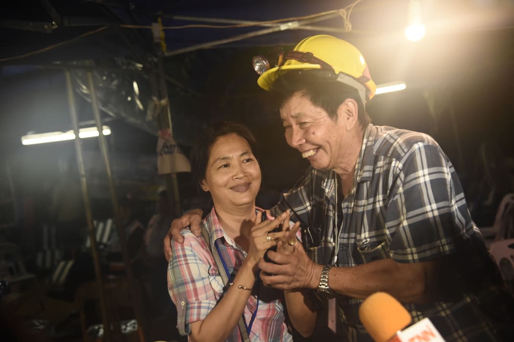 Family members of one of the missing boys celebrate while camping out near Than Luang cave following news all members of children's football team and their coach were alive in the cave at Khun Nam Nang Non Forest Park in the Mae Sai district of Chiang Rai province late July 2, 2018.