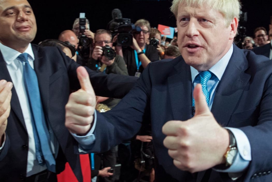 Boris Johnson acknowledges the applause from  members of his cabinet as he leaves after delivering his keynote speech on the final day of the annual Conservative Party conference.