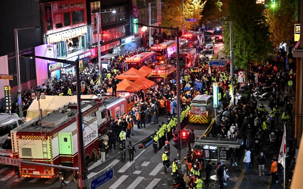 Crowds are seen around the area, where dozens of people suffered cardiac arrest, in the popular nightlife district of Itaewon in Seoul on October 30, 2022. - Dozens of people suffered from cardiac arrest in the South Korean capital Seoul, after thousands of people crowded into narrow streets in the city's Itaewon neighbourhood to celebrate Halloween, local officials said. (Photo by Jung Yeon-je / AFP)