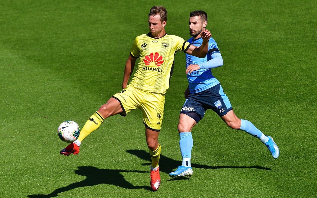 Phoenix's Jaushua Sotirio takes a pass with Sydney FC's Kosta Barbarouses during the A-League.
