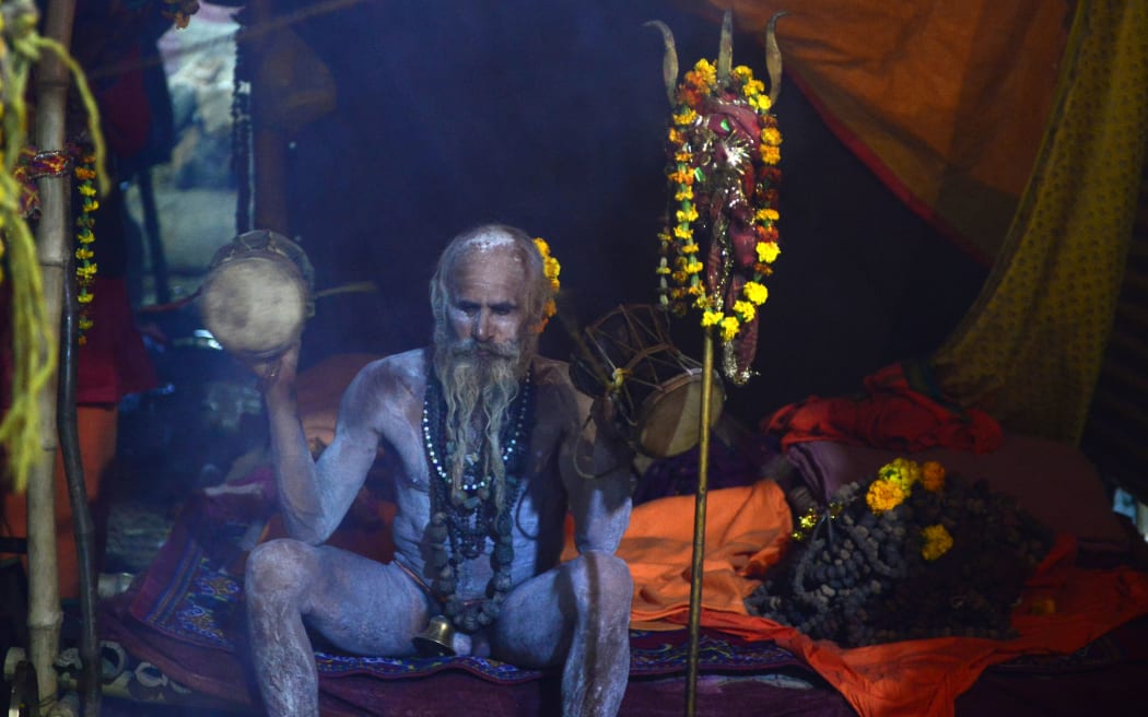 An Indian sadhu (Hindu holy man) sits inside his tent as he performs evening prayers.